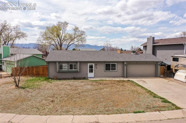 138 Hoedown Cir, Fountain, CO 80817 - ranch-style house featuring roof with shingles, fence, an attached garage, a mountain view, and concrete driveway