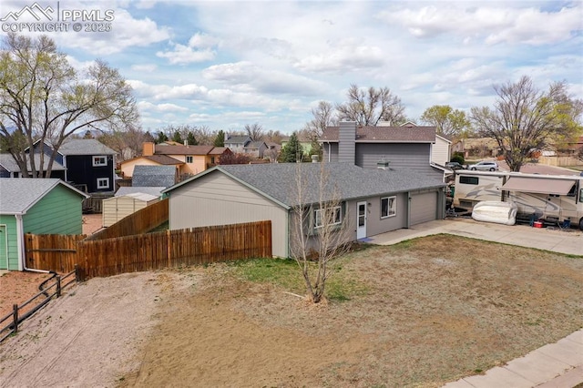 138 Hoedown Cir, Fountain, CO 80817 - view of front of house featuring a garage, fence, a residential view, driveway, and roof with shingles