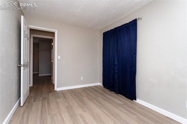 138 Hoedown Cir, Fountain, CO 80817 - empty room featuring baseboards, light wood-style floors, and a textured ceiling