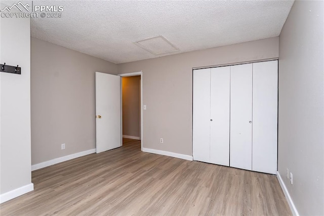 138 Hoedown Cir, Fountain, CO 80817 - unfurnished bedroom featuring light wood-type flooring, attic access, baseboards, and a textured ceiling