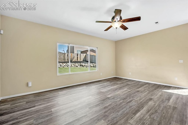 empty room featuring baseboards, a ceiling fan, wood finished floors, and visible vents