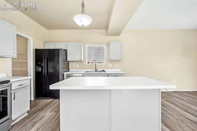kitchen with light wood-style flooring, a sink, black fridge, light countertops, and electric stove