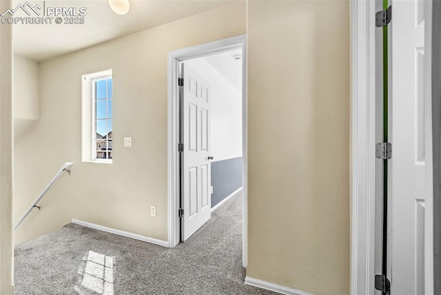 corridor with baseboards, carpet flooring, and an upstairs landing