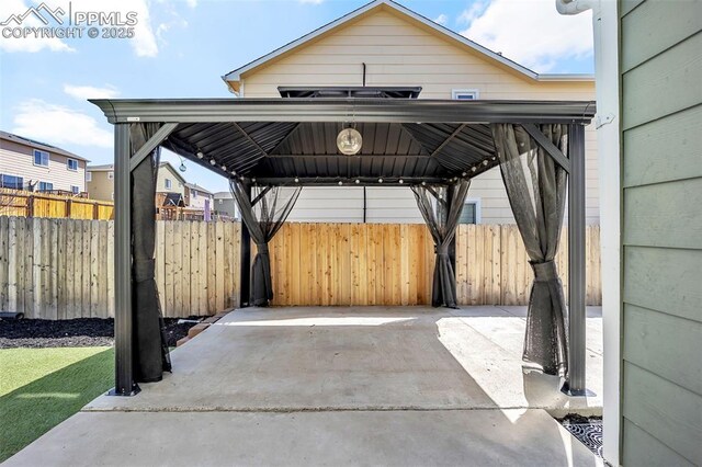 view of patio / terrace featuring a carport, fence, and a gazebo