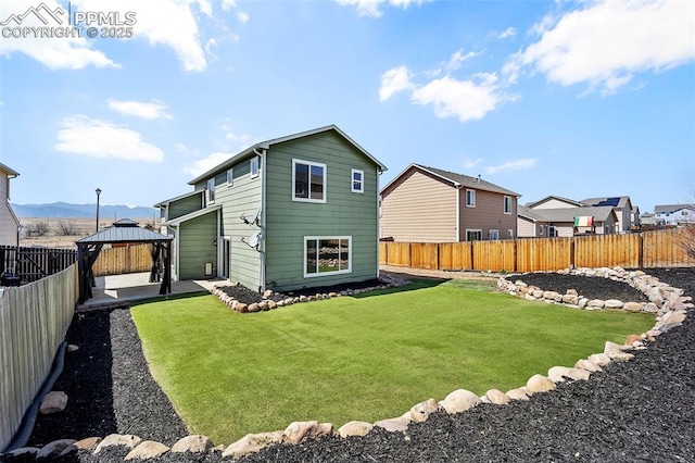 back of house featuring a gazebo, a lawn, a patio, and a fenced backyard