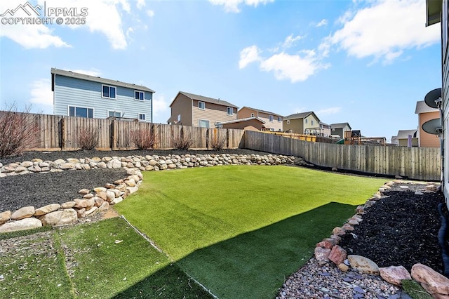 view of yard with a fenced backyard and a residential view