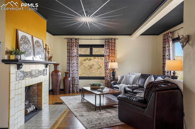 living room with wood finished floors and a tile fireplace