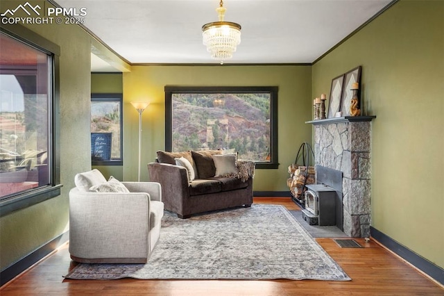 living area featuring crown molding, baseboards, a notable chandelier, and wood finished floors