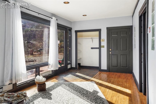 entrance foyer featuring baseboards, recessed lighting, and hardwood / wood-style flooring