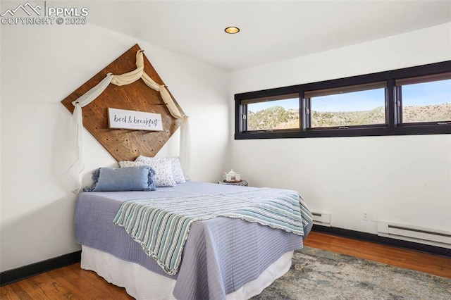 bedroom with baseboards, recessed lighting, wood finished floors, and baseboard heating
