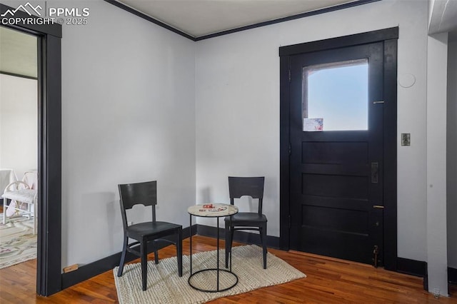 entrance foyer with wood finished floors, baseboards, and ornamental molding