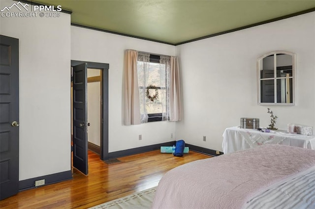 bedroom featuring wood finished floors and baseboards