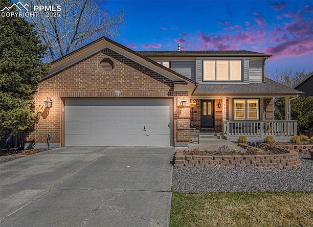 traditional-style house featuring brick siding, an attached garage, covered porch, and concrete driveway