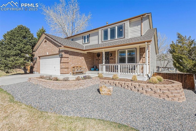traditional-style house with brick siding, covered porch, a garage, and concrete driveway