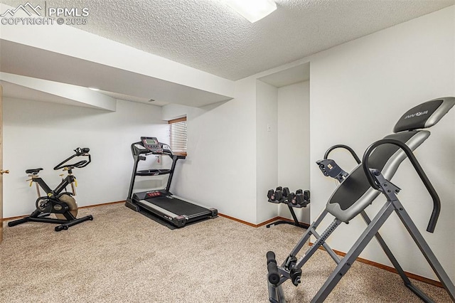 workout room featuring carpet flooring, a textured ceiling, and baseboards
