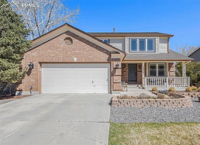 traditional-style home with concrete driveway, roof with shingles, a porch, brick siding, and a garage
