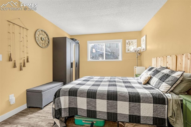 5030 El Camino Dr Unit 1, Colorado Springs, CO 80918 - bedroom with a textured ceiling, baseboards, and light wood-style floors