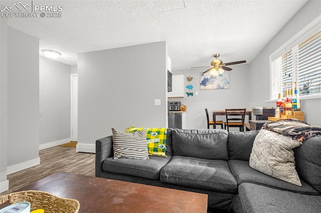 5030 El Camino Dr Unit 1, Colorado Springs, CO 80918 - living room with a textured ceiling, baseboards, a ceiling fan, and wood finished floors