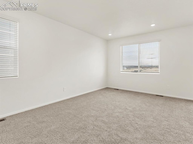 spare room featuring recessed lighting, carpet, visible vents, and baseboards