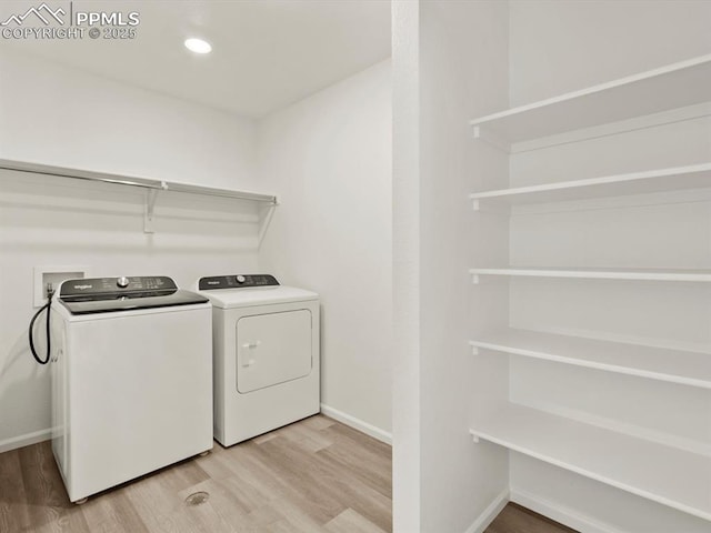 laundry room with recessed lighting, laundry area, light wood-style floors, washing machine and clothes dryer, and baseboards
