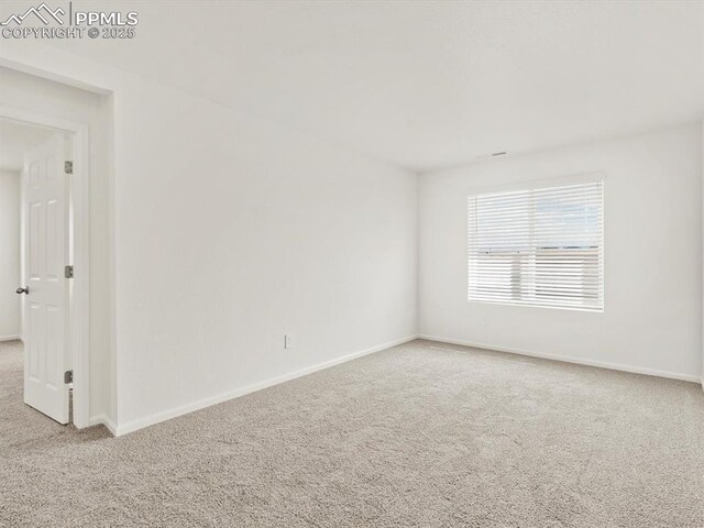 carpeted spare room with baseboards