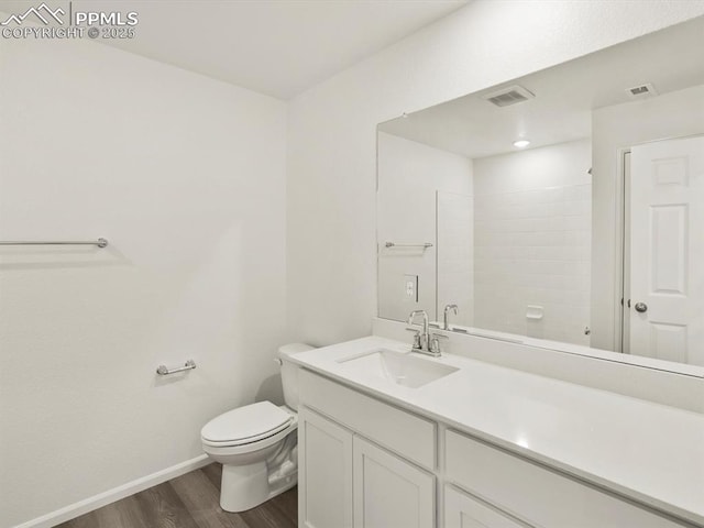 full bathroom featuring toilet, visible vents, baseboards, wood finished floors, and vanity