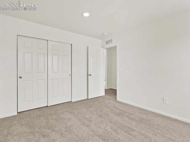 unfurnished bedroom featuring baseboards, visible vents, a closet, and carpet flooring