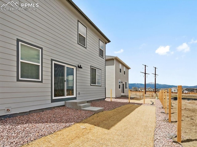 rear view of property featuring fence and a mountain view