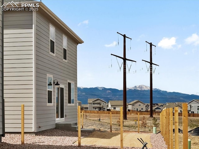 view of yard featuring fence, a residential view, and a mountain view