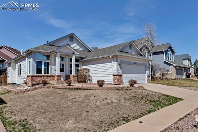 4626 Hotspur Dr, Colorado Springs, CO 80922 - view of front of home with brick siding, an attached garage, driveway, and roof with shingles