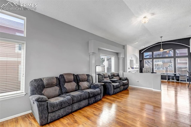 4626 Hotspur Dr, Colorado Springs, CO 80922 - living room with vaulted ceiling, wood finished floors, a textured ceiling, and a healthy amount of sunlight
