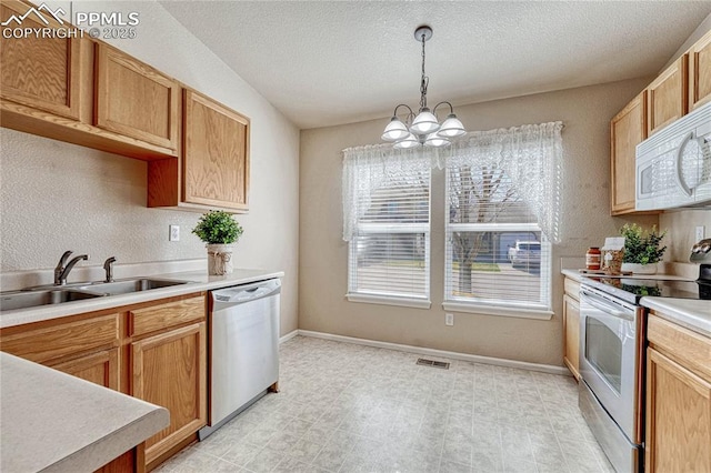 5542 Sunshade Pt, Colorado Springs, CO 80923 - kitchen with a chandelier, appliances with stainless steel finishes, a sink, light countertops, and decorative light fixtures