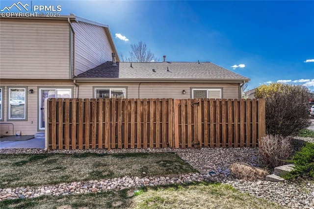 5542 Sunshade Pt, Colorado Springs, CO 80923 - back of house with a shingled roof, fence, and a patio area