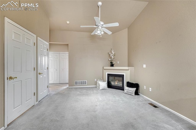 5542 Sunshade Pt, Colorado Springs, CO 80923 - unfurnished living room with visible vents, baseboards, carpet flooring, and a glass covered fireplace
