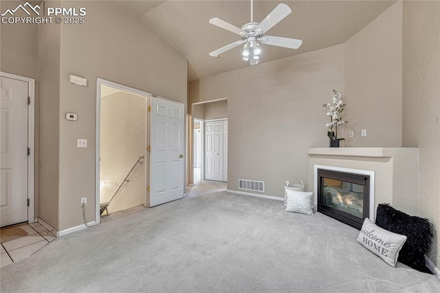 5542 Sunshade Pt, Colorado Springs, CO 80923 - unfurnished living room with visible vents, ceiling fan, carpet floors, high vaulted ceiling, and a glass covered fireplace