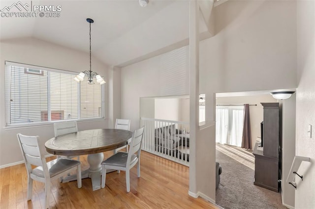 dining space with lofted ceiling, light wood-style floors, a notable chandelier, and a healthy amount of sunlight