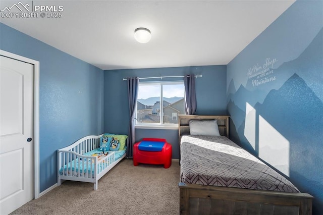 bedroom with a crib, baseboards, and carpet flooring
