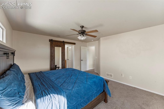 bedroom featuring a barn door, a ceiling fan, baseboards, carpet flooring, and visible vents
