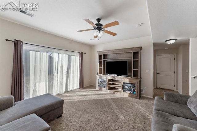 carpeted living room featuring baseboards, a ceiling fan, and visible vents