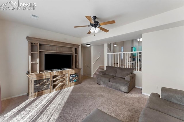 living room with carpet floors, visible vents, a ceiling fan, and baseboards