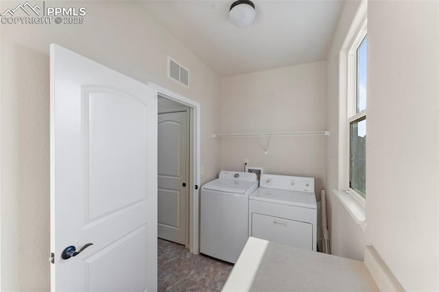 laundry room featuring washing machine and dryer, visible vents, and laundry area