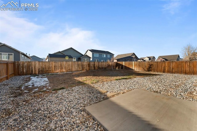 view of yard featuring a fenced backyard, a residential view, and a patio