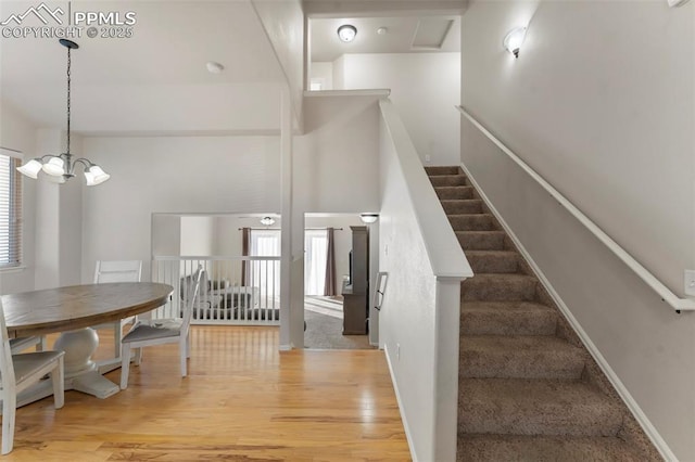 staircase with a chandelier and wood finished floors