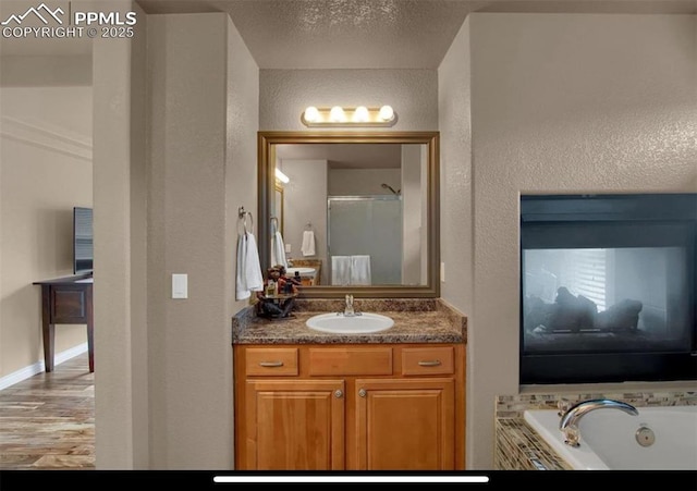 8723 Stony Creek Dr, Colorado Springs, CO 80924 - bathroom featuring vanity, a jetted tub, and a textured wall
