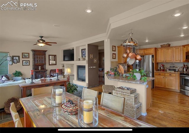 8723 Stony Creek Dr, Colorado Springs, CO 80924 - dining area with a glass covered fireplace, a ceiling fan, recessed lighting, and light wood finished floors
