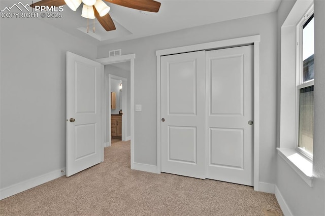 unfurnished bedroom with visible vents, baseboards, a closet, a ceiling fan, and light carpet
