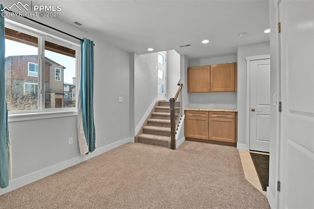 interior space featuring baseboards, light carpet, recessed lighting, stairs, and visible vents