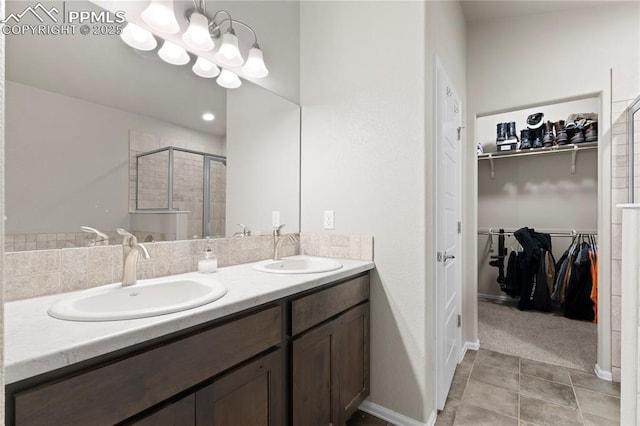 955 S Los Charros Dr, Pueblo West, CO 81007 - bathroom with a walk in closet, double vanity, a sink, and a stall shower