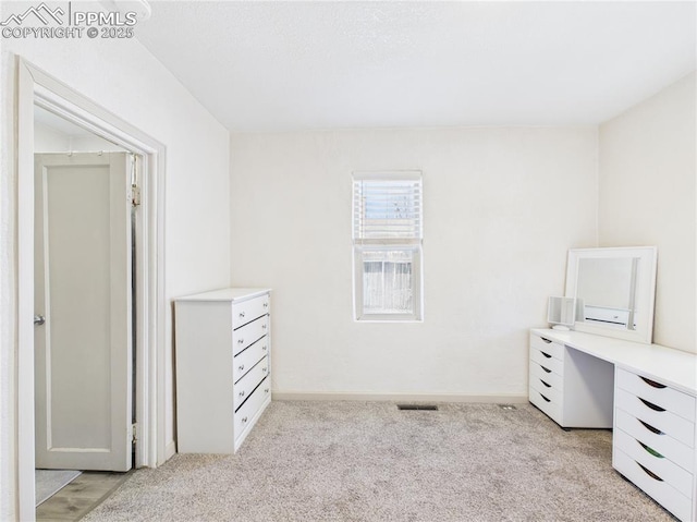 unfurnished bedroom with light colored carpet, baseboards, and visible vents