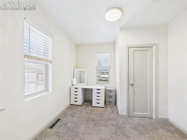 unfurnished office with visible vents, baseboards, and carpet floors